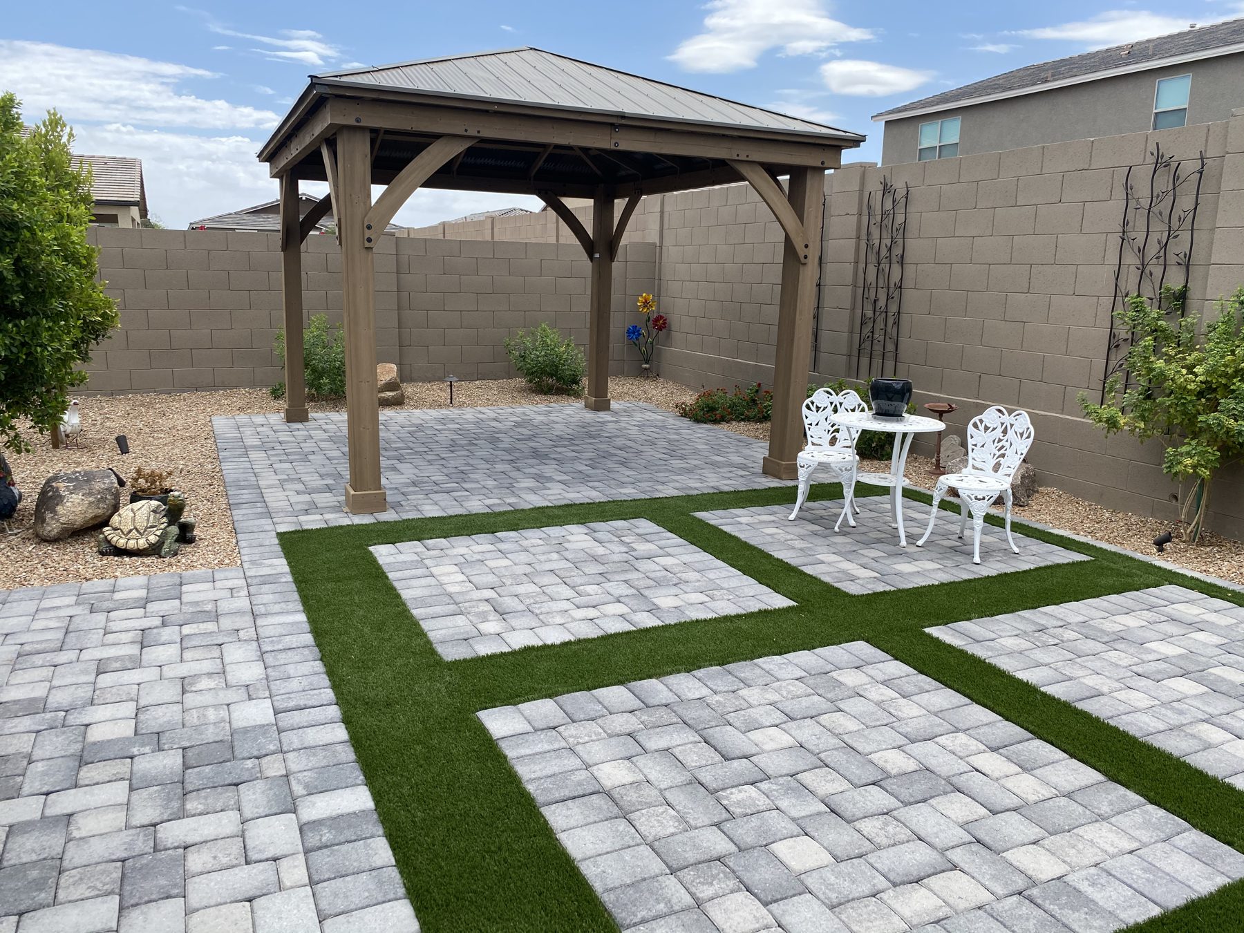 Wood gazebo over a paver patio with turf inlays