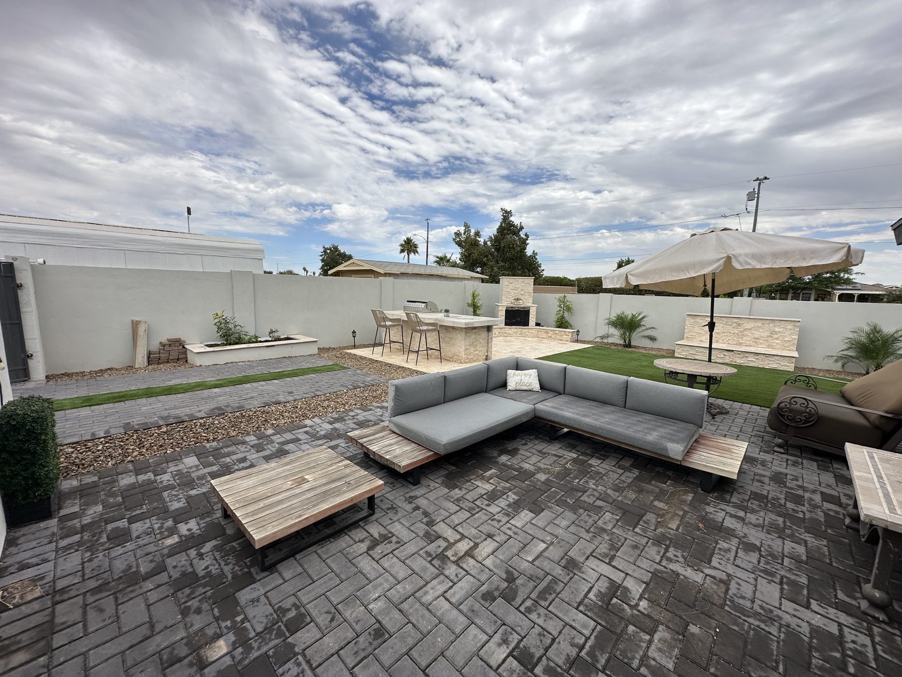 Herringbone paver patio with outdoor lounge seating, turf and a built-in BBQ